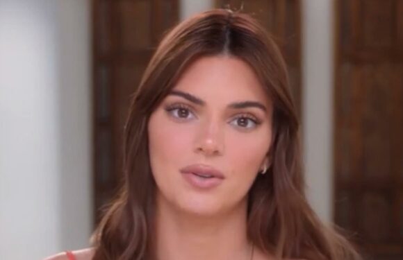 Kendall Jenner goes braless and nearly spills out of orange top in new clip as fans think she secretly got a boob job | The Sun