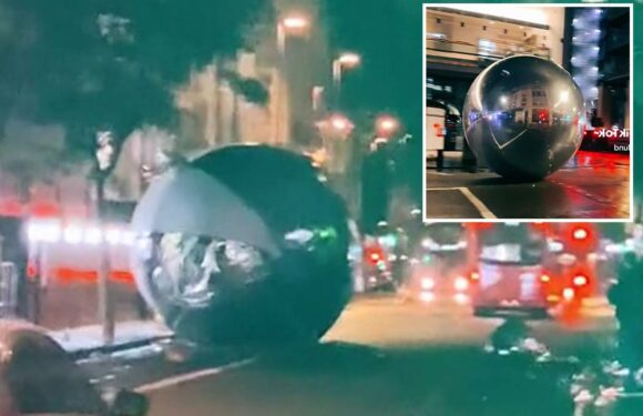 Moment giant Christmas baubles bigger than cars roll down London street after high winds blow them down | The Sun