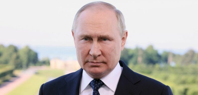 Vladimir Putin’s hand turns purple as he’s seen shaking and clutching chair