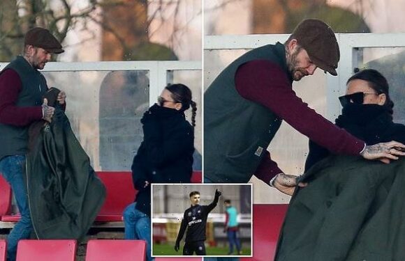 David Beckham offers coat to wife Victoria