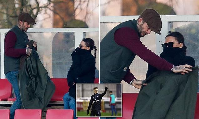 David Beckham offers coat to wife Victoria