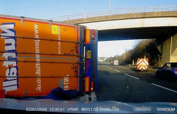 Hair-raising moment HGV topples onto its side after clipping M11