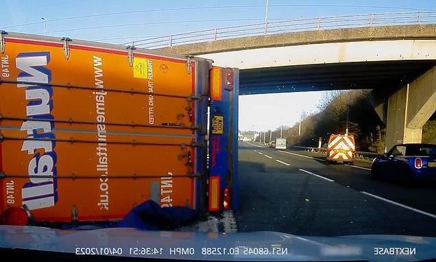 Hair-raising moment HGV topples onto its side after clipping M11