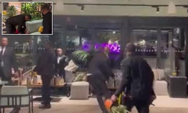 Moment men in suits start throwing punches and plant pots in fight
