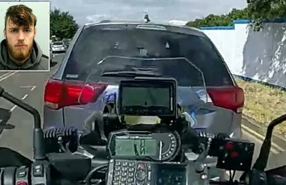 Shocking moment banned driver reverses into motorbike cop