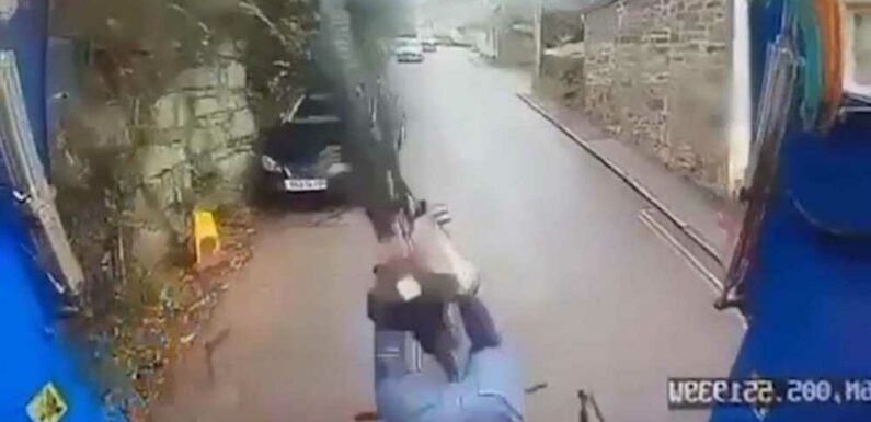 Terrifying moment cyclist topples into back of moving bin lorry after losing control down steep hill | The Sun