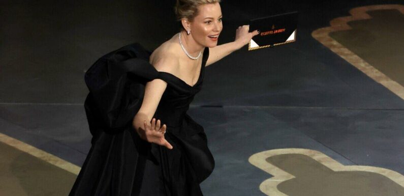 Elizabeth Banks trips on Oscars stage twice