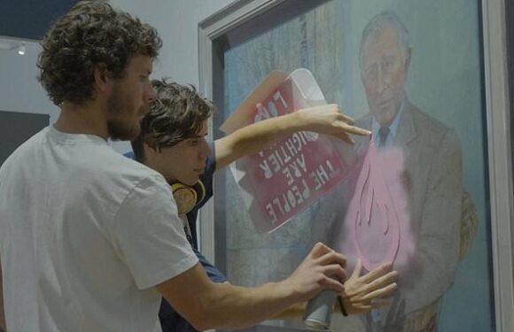 Moment eco vandals spray paint on a portrait of King Charles