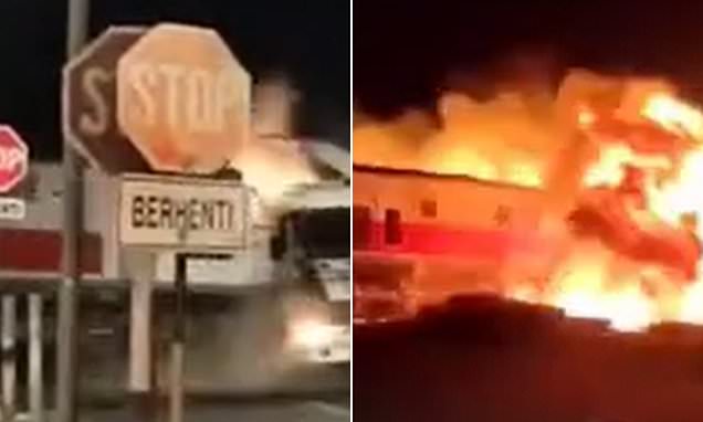 Truck explodes in a fireball after being slammed by a train