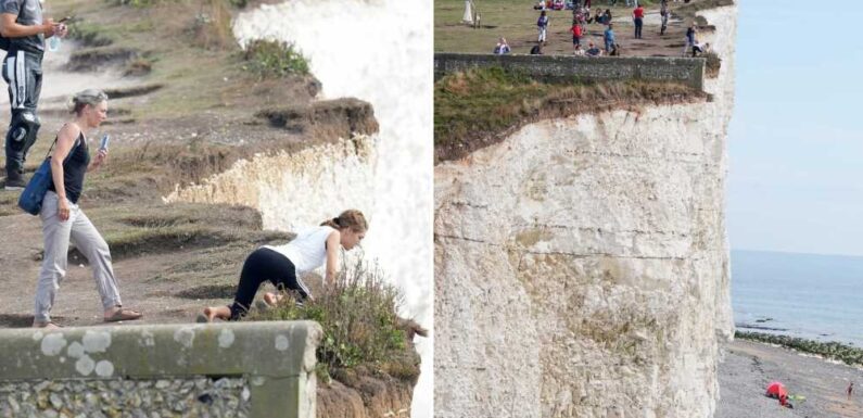 Idiot tourists pose for selfies and teenagers hang over 150ft cliff at Birling gap as adults WATCH | The Sun