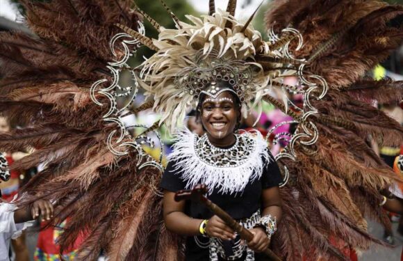 Notting Hill revellers dance in fabulous feather outfits as they hit the streets for famous carnival | The Sun