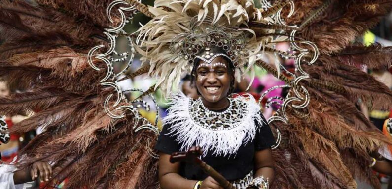 Notting Hill revellers dance in fabulous feather outfits as they hit the streets for famous carnival | The Sun