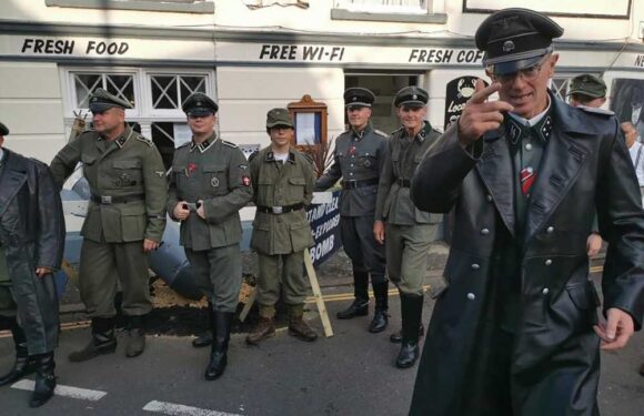 Men dressed as Nazi SS clash with furious locals as cops escort them off high street during 1940s festival | The Sun