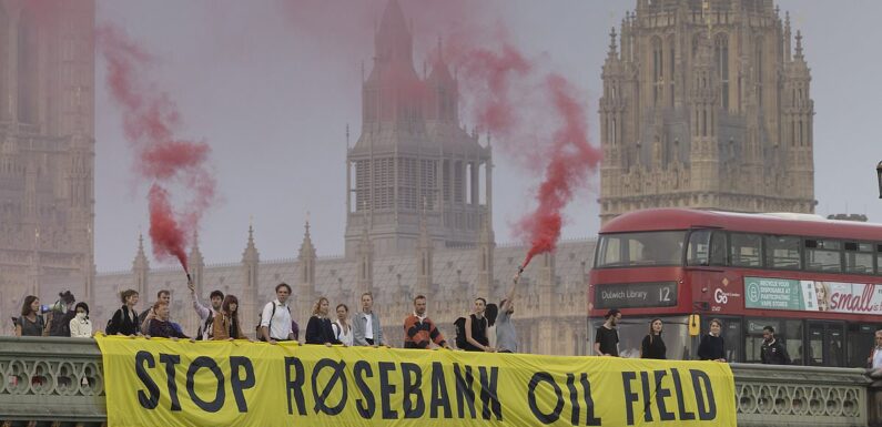 Protesters light flares on Westminster Bridge over Rosebank oil field