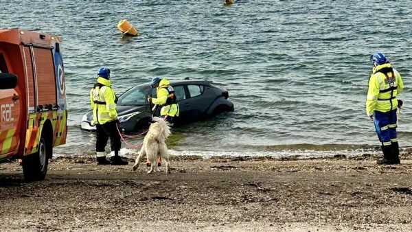 Got that sinking feeling… Couple's car stranded on beach at sunrise