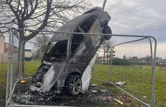 Burnt-out wreck of flipped car left stuck up a lamppost after cops attacked in 'Little Beirut' estate mayhem | The Sun