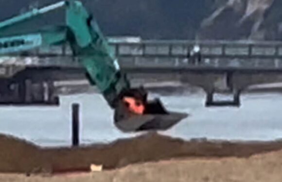 Digger driver uses bucket of his machine to rescue stranded workmate