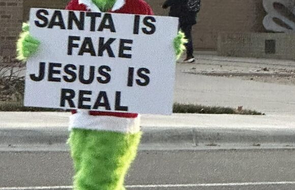 Man in Grinch outfit with Santa is fake sign disrupts school drop-off