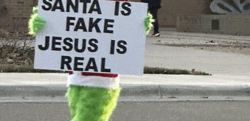 Man in Grinch outfit with Santa is fake sign disrupts school drop-off